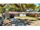 Inviting single-story home featuring a convenient carport and a beautifully shaded front yard at 7303 N Branch Ave, Tampa, FL 33604