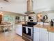 Open kitchen view featuring stainless steel range and hood, butcher block counters, and adjacent dining area at 7303 N Branch Ave, Tampa, FL 33604