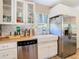 Bright kitchen featuring stainless steel refrigerator, white cabinets, and a farmhouse sink at 7303 N Branch Ave, Tampa, FL 33604