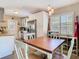 Well-equipped kitchen with stainless steel appliances and a bright dining area with white chairs at 7303 N Branch Ave, Tampa, FL 33604