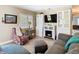 Well-lit living room featuring a gray sectional sofa, fireplace, and a patterned accent chair at 7303 N Branch Ave, Tampa, FL 33604