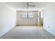 Bedroom with neutral carpet, window, ceiling fan, and bathroom access at 7330 Cherry Laurel Dr, Port Richey, FL 34668
