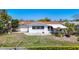 Charming single-story home with a well-maintained lawn, a white exterior, and mature landscaping at 7330 Cherry Laurel Dr, Port Richey, FL 34668