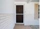 Close-up of a front door with unique carvings in a white brick wall at 7330 Cherry Laurel Dr, Port Richey, FL 34668