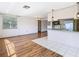 Bright living room flows to kitchen featuring wood floors and stainless steel refrigerator at 7330 Cherry Laurel Dr, Port Richey, FL 34668