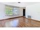 Spacious living room with a large window and wood-style flooring at 7330 Cherry Laurel Dr, Port Richey, FL 34668