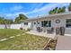 Inviting front entrance with a well-kept lawn, a cozy seating area, and colorful landscaping enhancing the home's appeal at 7401 35Th N Ave, St Petersburg, FL 33710