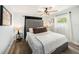 Main bedroom featuring a plush bed with an upholstered headboard, ceiling fan, and wood-look flooring at 7401 35Th N Ave, St Petersburg, FL 33710