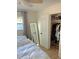 Bright bedroom with a bed, full length mirror, and closet with clothes and shelves at 801 53Rd N Ter, St Petersburg, FL 33703