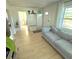 Bright living room featuring a gray couch, hardwood floors, and ample natural light from the large windows at 801 53Rd N Ter, St Petersburg, FL 33703
