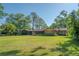 Spacious backyard view of the house with a large lawn at 8136 Honeybee Ln, Tampa, FL 33635