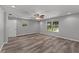 Bedroom with neutral paint, ceiling fan, vinyl floors, and natural light from large windows at 8136 Honeybee Ln, Tampa, FL 33635