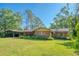 Charming single-story brick home with a covered carport and lush landscaping at 8136 Honeybee Ln, Tampa, FL 33635