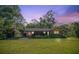 Exterior view of home with carport, mature landscaping, and a spacious yard at 8136 Honeybee Ln, Tampa, FL 33635