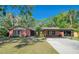 Charming brick home featuring a covered carport and lush landscaping at 8136 Honeybee Ln, Tampa, FL 33635