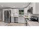 Modern kitchen with stainless steel appliances, granite countertops, and white cabinets at 8136 Honeybee Ln, Tampa, FL 33635