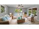 Bright living room with rattan furniture, ceiling fan, and natural light at 8136 Honeybee Ln, Tampa, FL 33635
