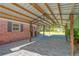 Covered patio with paver flooring adjacent to brick home and lush backyard at 8136 Honeybee Ln, Tampa, FL 33635
