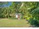 Wooden shed in the spacious backyard with lush tropical landscaping at 8136 Honeybee Ln, Tampa, FL 33635