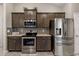 Modern kitchen featuring stainless steel appliances, sleek countertops, and dark wood cabinetry at 8285 Kingsdale St, Spring Hill, FL 34608