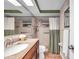 Well-lit bathroom featuring tile shower, granite countertop and large mirror at 10035 Cherry Creek Ln, Port Richey, FL 34668