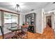 Cozy dining room with chandelier lighting, hardwood floors and a view to a large window at 10035 Cherry Creek Ln, Port Richey, FL 34668