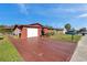 Wide driveway with a view of the one-story home, landscaping and blue sky at 10035 Cherry Creek Ln, Port Richey, FL 34668