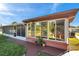 Home exterior featuring a large, screened lanai and plenty of windows with a view of the backyard at 10035 Cherry Creek Ln, Port Richey, FL 34668