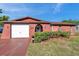 Charming one-story home with colorful red exterior, manicured lawn, and attached garage under a bright blue sky at 10035 Cherry Creek Ln, Port Richey, FL 34668