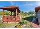 Backyard gazebo with wood deck and seating area, enhancing outdoor relaxation and enjoyment of the landscaped yard at 10035 Cherry Creek Ln, Port Richey, FL 34668
