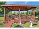 Beautiful wooden gazebo with seating, ceiling fans, and lighting, creating an ideal outdoor retreat at 10035 Cherry Creek Ln, Port Richey, FL 34668