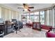 Bright home office featuring large windows, tiled flooring, and a ceiling fan for comfortable productivity at 10035 Cherry Creek Ln, Port Richey, FL 34668