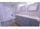Bathroom featuring a double sink vanity, wood-look tile flooring, hexagon tile backsplash, and a tub-shower combo at 11118 Golden Silence Dr, Riverview, FL 33579