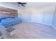 Large bedroom with a ceiling fan, wood accent wall and wood-look flooring at 11118 Golden Silence Dr, Riverview, FL 33579