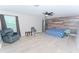 Spacious bedroom with light wood-look floors, a wood accent wall, and comfortable seating at 11118 Golden Silence Dr, Riverview, FL 33579