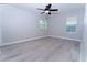 An empty bedroom with wood-look flooring and natural light from two windows at 11118 Golden Silence Dr, Riverview, FL 33579
