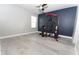 Spacious bedroom with a blue accent wall and exercise machine, offering ample floor space at 11118 Golden Silence Dr, Riverview, FL 33579