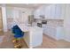 Bright kitchen features an island with marble countertop, stainless appliances, and light blue cabinets at 11118 Golden Silence Dr, Riverview, FL 33579