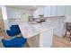 Close-up of kitchen island with marble countertop, stainless steel sink and light blue cabinetry at 11118 Golden Silence Dr, Riverview, FL 33579