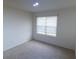 Cozy bedroom with neutral carpet and a window with blinds, providing ample natural light at 11517 Koti Creek Ln, Thonotosassa, FL 33592