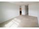 Spacious carpeted bedroom with an open doorway, complemented by neutral walls and ample natural light at 11517 Koti Creek Ln, Thonotosassa, FL 33592