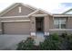 Inviting home exterior featuring a two-car garage and a cozy, covered entrance at 11517 Koti Creek Ln, Thonotosassa, FL 33592