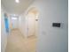 Bright hallway with neutral tile flooring and white walls leading to the front door and rooms at 11517 Koti Creek Ln, Thonotosassa, FL 33592