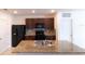 Modern kitchen featuring dark wood cabinets, granite countertops, and stainless steel appliances at 11517 Koti Creek Ln, Thonotosassa, FL 33592