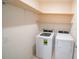 Functional laundry room with washer, dryer, and open shelving for optimal storage at 11517 Koti Creek Ln, Thonotosassa, FL 33592