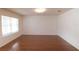 Bright living room features hardwood floors, a modern ceiling light, and a window with adjustable blinds at 11517 Koti Creek Ln, Thonotosassa, FL 33592