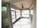 Enclosed patio featuring tiled flooring, multiple windows, and a ceiling fan for outdoor enjoyment at 11517 Koti Creek Ln, Thonotosassa, FL 33592