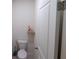 Compact powder room with a white toilet, small shelf, and a white door at 11517 Koti Creek Ln, Thonotosassa, FL 33592
