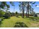 Large backyard with a well-manicured lawn, mature trees, and a wooden fence at 11803 70Th St, Largo, FL 33773