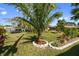 Lush backyard featuring a well-maintained lawn, mature trees, and landscape features at 11803 70Th St, Largo, FL 33773